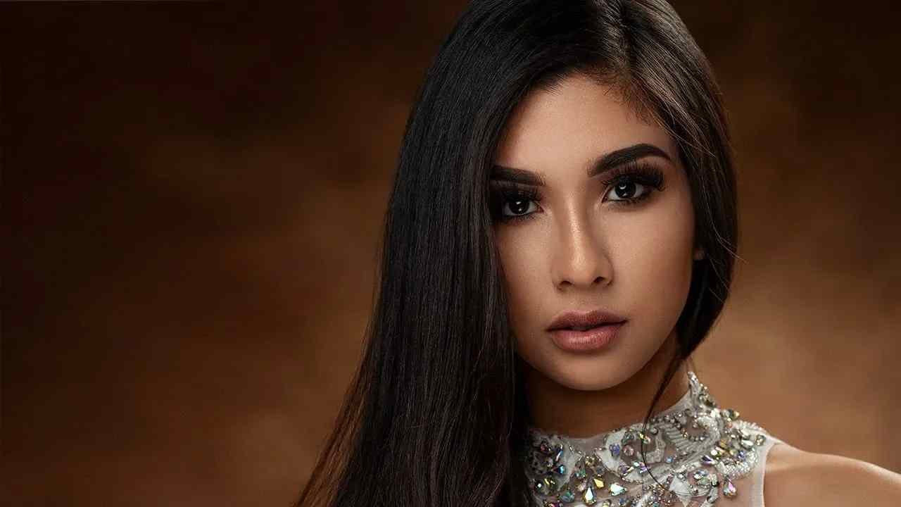 Studio portrait of model with long dark hair up-close.